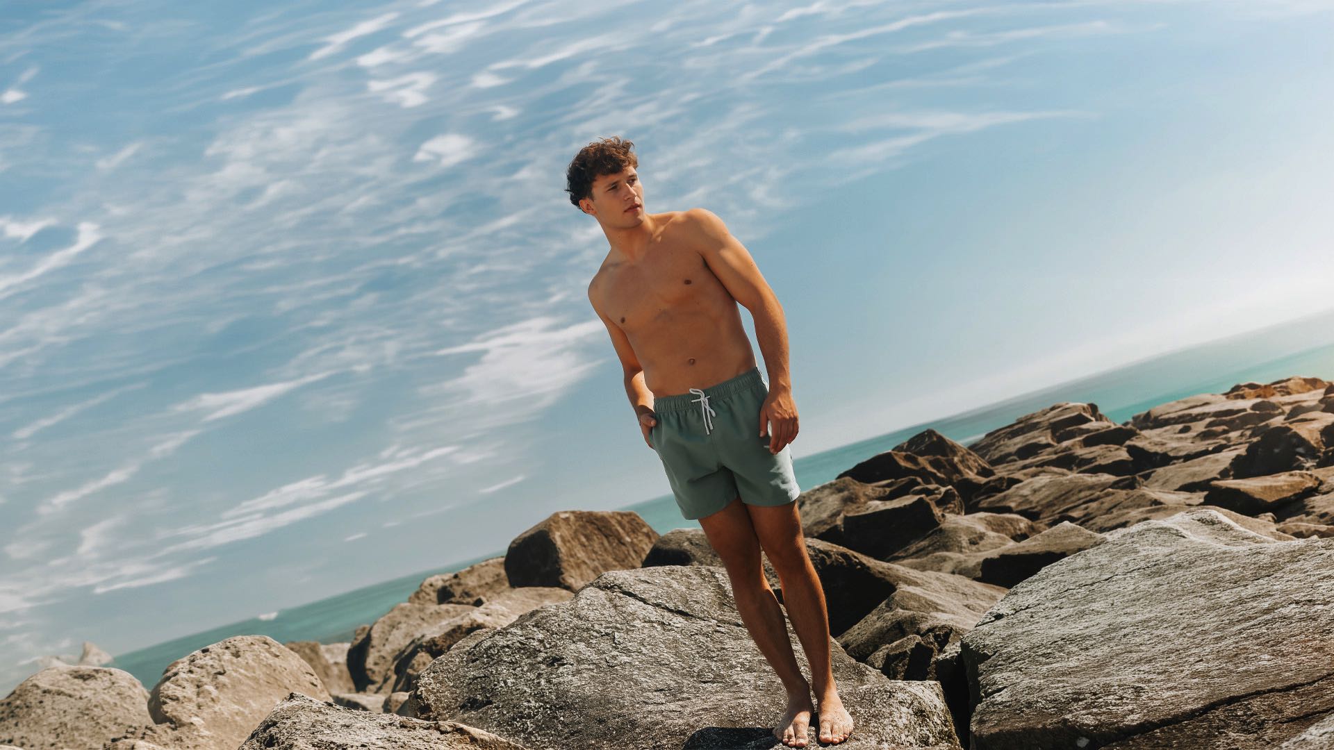 men wearing olive swim trunk at the beach
